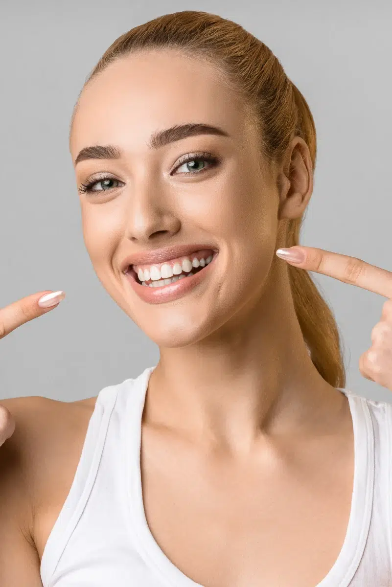 Femme souriante pointant ses dents
