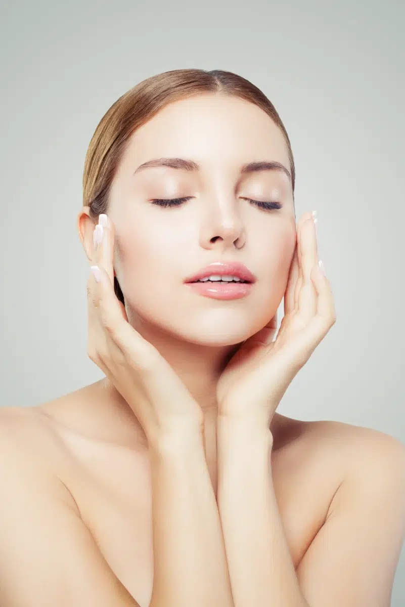 Femme aux yeux fermés touchant son visage